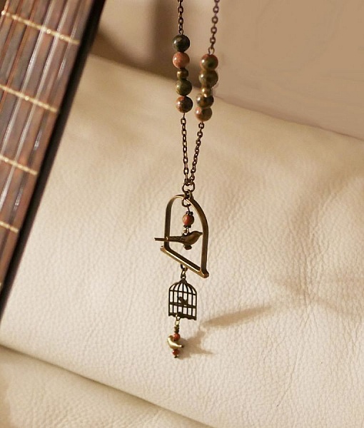 Halsband med l&aring;ng f&aring;gel som h&auml;ngsmycke