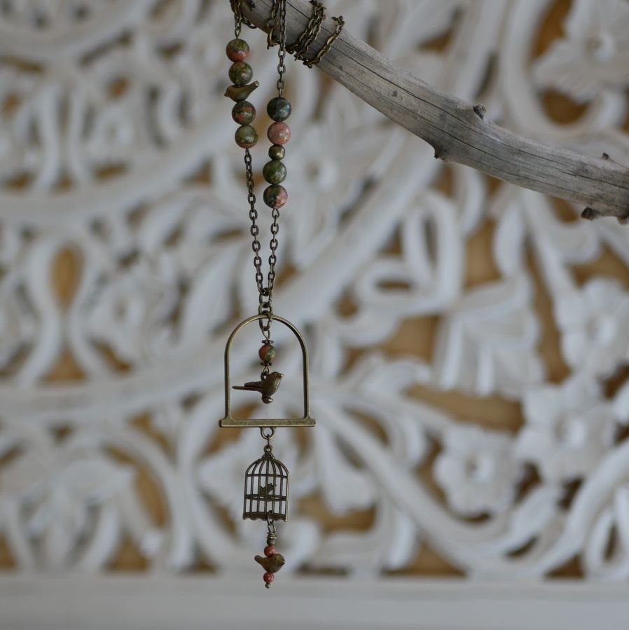 Halsband med lång fågel som hängsmycke