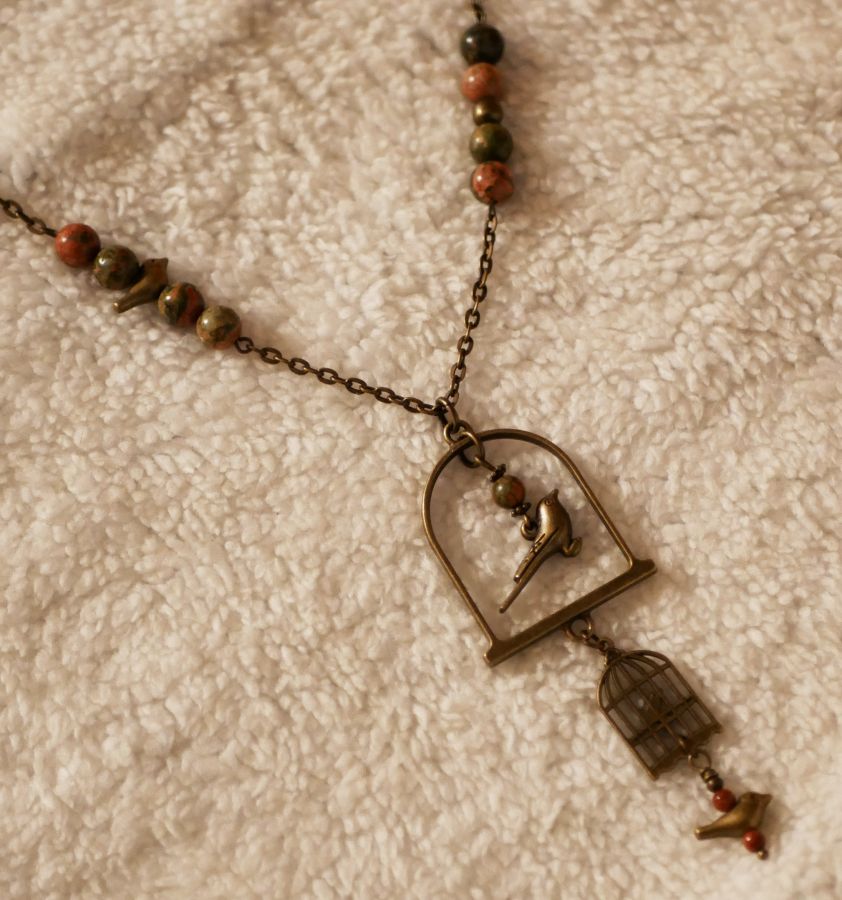 Halsband med lång fågel som hängsmycke