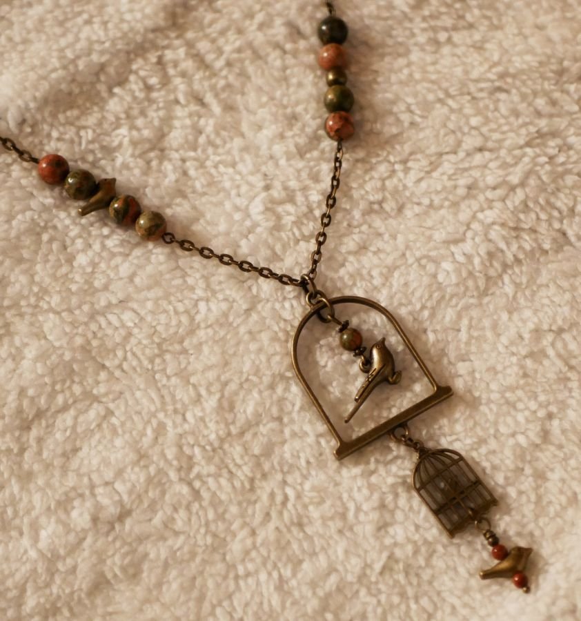 Halsband med lång fågel som hängsmycke