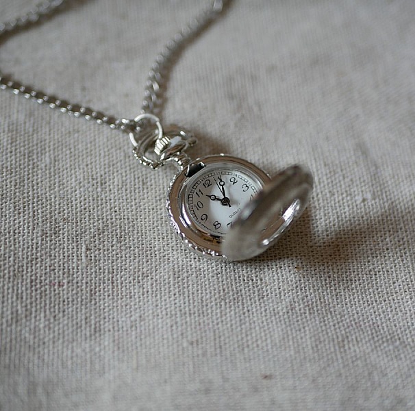 Rundt silverpl&auml;terat fickur h&auml;ngande p&aring; kedja